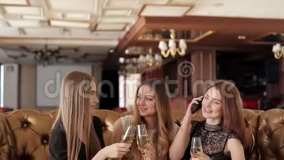 三个年轻女孩在派对上喝着香槟和聊天视频的预览图