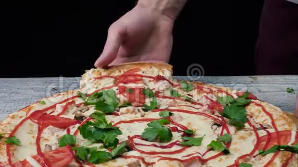 男人用手拿一块披萨框架男性手拿着带有弹性奶酪的披萨片视频的预览图