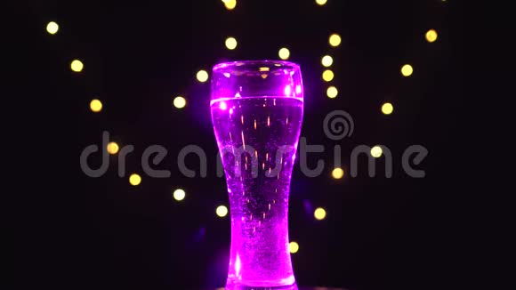 洋红光中的一杯水在旋转洋红鸡尾酒酒吧概念视频的预览图