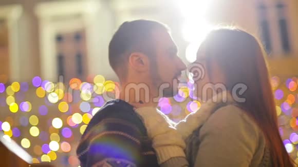浪漫的夫妇与高加索人的外表亲吻和拥抱灯光和烟花在背景上年轻夫妇视频的预览图