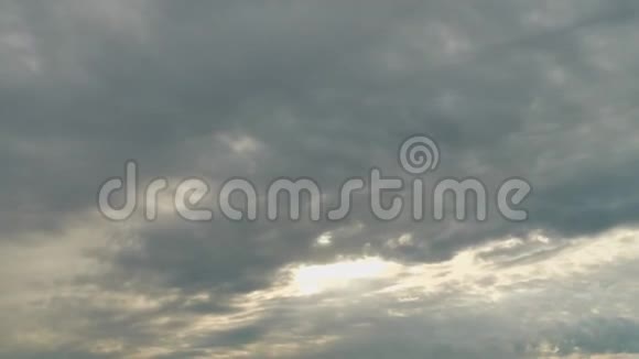 阳光从覆盖天空的灰色云层后面照射出来时间流逝视频的预览图
