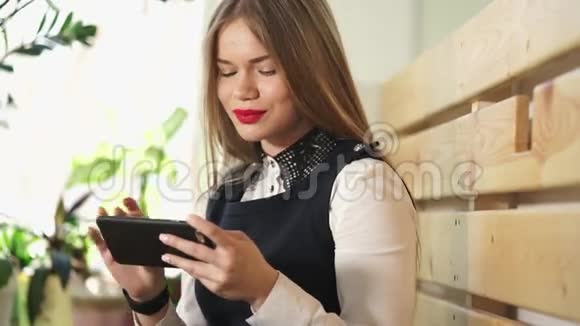 年轻漂亮的女人在手机上看社交网络上的照片视频的预览图