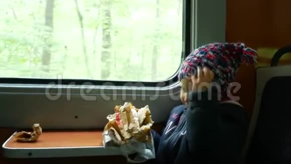 孩子在靠近窗户的火车上女孩吃馅饼坐在火车上视频的预览图