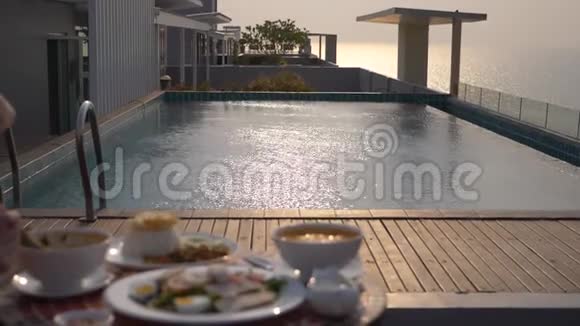 泰式菜肴游泳池旁的桌子泰国传统午餐在游泳池旁改变焦点视频的预览图