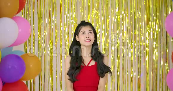 美丽的亚洲女人喜欢用五彩纸屑在金色闪光的背景视频的预览图