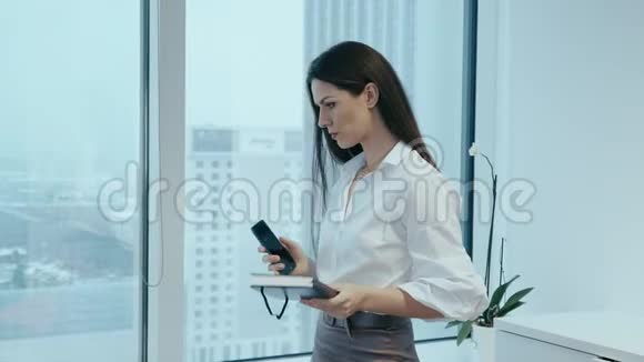 漂亮的女商人在玻璃办公室打电话视频的预览图