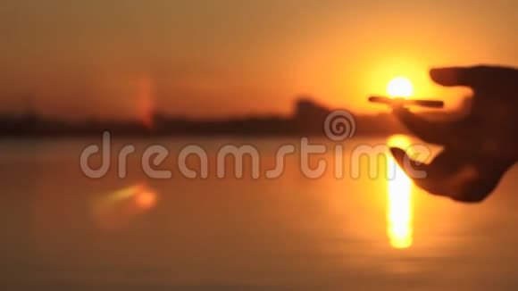 日落时在池塘背景下旋转旋转的手视频的预览图