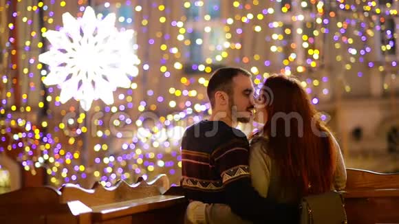 浪漫的夫妇与高加索人的外表亲吻和拥抱灯光和烟花在背景上年轻夫妇视频的预览图