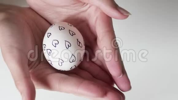 无法辨认的女人手里拿着一个图案的鸡蛋复活节彩蛋复活节假期的概念双手视频的预览图