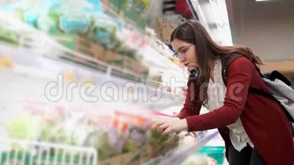 年轻女子在杂货店里选择新鲜沙拉视频的预览图