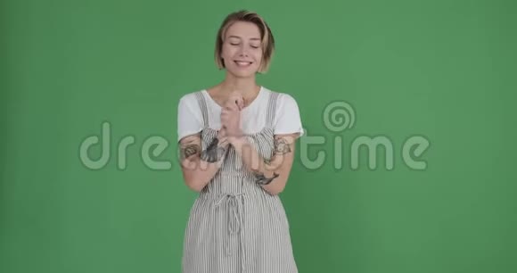 在绿色背景下摆姿势的快乐女人视频的预览图