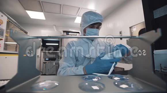 光学师拿出镜片放在实验室的金属桌上视频的预览图