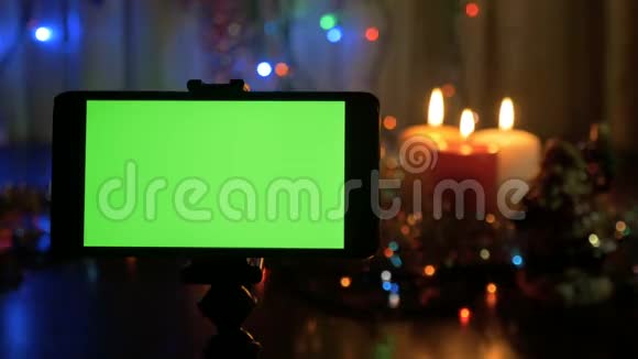 带有绿色屏幕的智能手机新年背景模糊一个很好的机会来添加你的问候视频视频的预览图