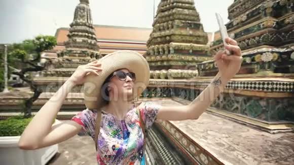 泰国曼谷寺庙观光期间年轻女游客用智能手机自拍视频的预览图