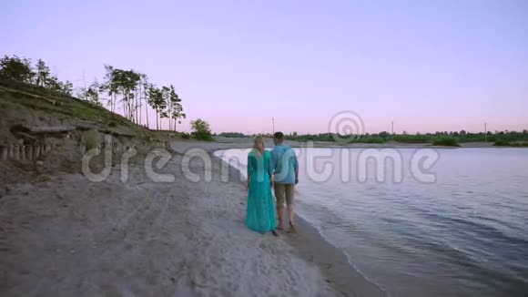 情侣牵手在海滩日落蜜月度假旅游快乐浪漫的年轻情人男人和女人视频的预览图