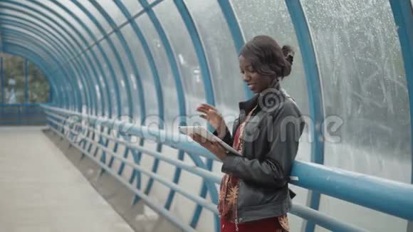 非裔美国女孩学生在街道城市街道地铁上用平板电脑工作幸福地关门视频的预览图