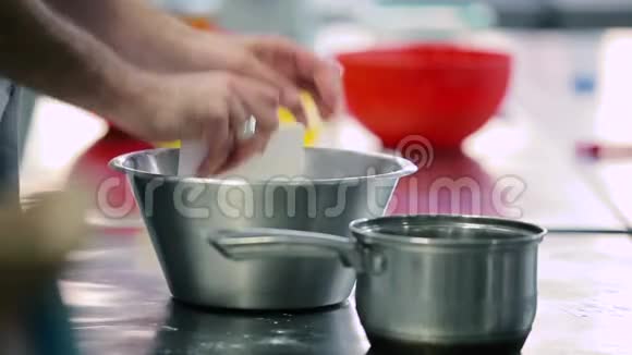 男人在厨房用水和面粉揉面视频的预览图