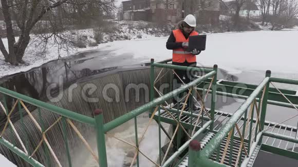 冬季在防洪闸附近工作的工程师视频的预览图