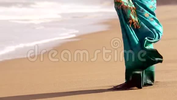 海浪拍打着站在沙滩上的女人的脚视频的预览图
