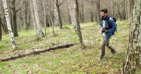 徒步穿越树林寻找照片的人在后面真正的人千禧旅行者背包客成年男性视频的预览图