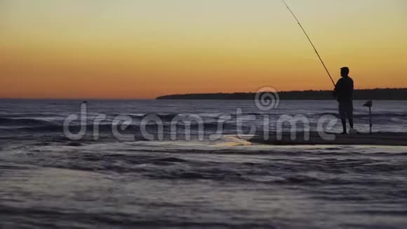 在海上日落时有旋转剪影的渔夫视频的预览图