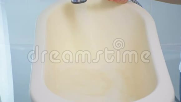 母亲用水和泡沫填充婴儿洗澡4K镜头视频的预览图