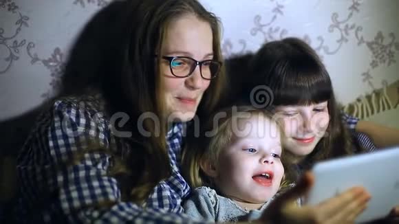 妈妈和孩子们在家拿着平板电脑看动画片和玩视频的预览图