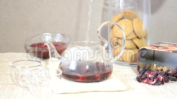 早餐红茶酿造工艺餐桌茶壶中红茶茶叶木槿和两个玻璃杯视频的预览图
