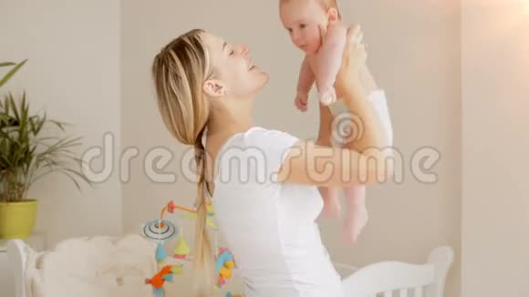 幸福的年轻母亲抱着3个月大的婴儿尿布的肖像视频的预览图