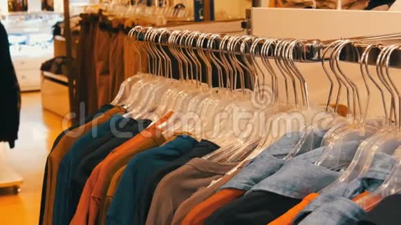 时尚的青年服装挂在购物中心的服装店的衣架上视频的预览图