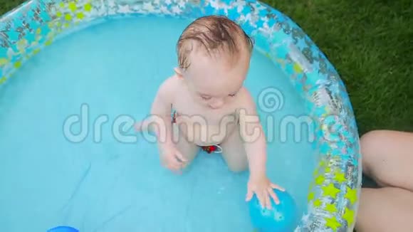 妈妈在一岁的小男孩在充气游泳池里游泳视频的预览图