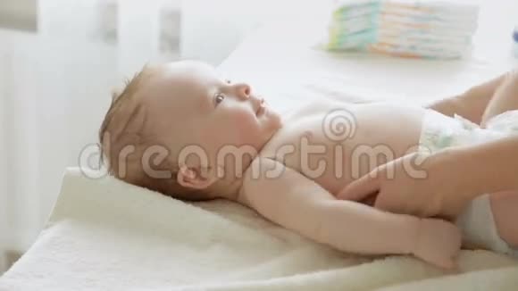 3个月大的男孩躺在换尿布的桌子上视频的预览图