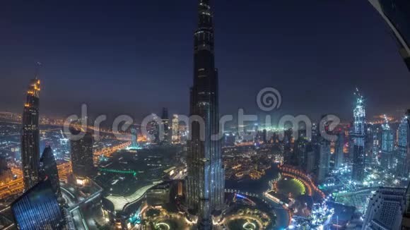 迪拜市中心的全景式天际线景观包括购物中心喷泉和BurjKhalifa的空中夜晚直到白天视频的预览图