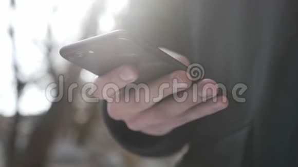 男性在户外用更大的黑色智能手机打字短信概念每秒60帧视频的预览图