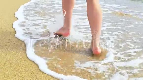 美丽的女人腿沿着沙滩奔跑在水里行走视频的预览图