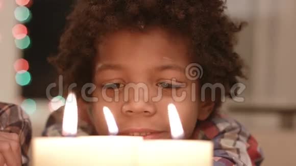 微笑的男孩看着蜡烛视频的预览图