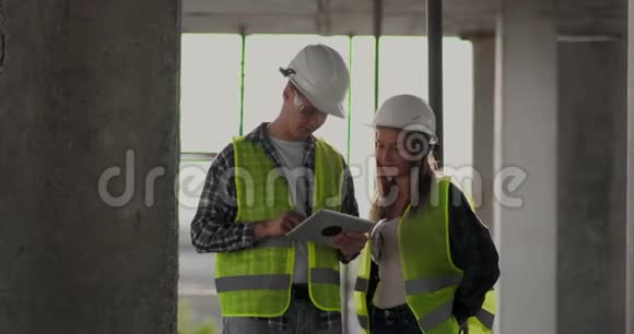 在脚手架施工计划或施工计划上讨论的团队或建筑师建筑工人或戴头盔的工人视频的预览图