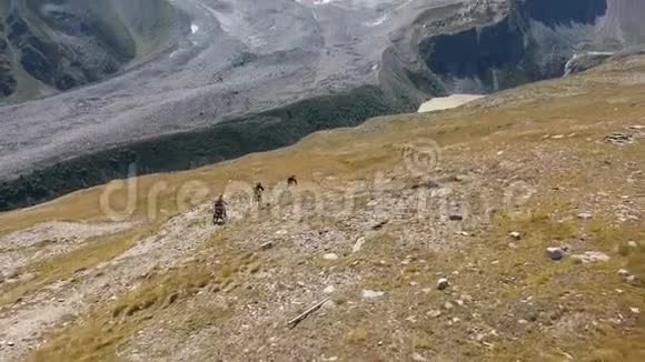 一些山地自行车手在高山上骑车到湖边视频的预览图