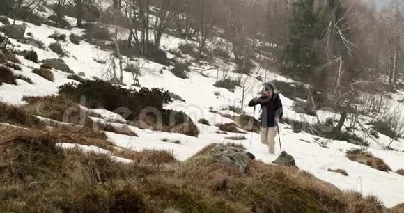 徒步旅行者背着背包走在雪地小径上在后面真正的背包客成人徒步旅行或徒步旅行视频的预览图
