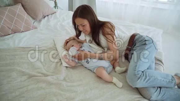年轻的母亲用瓶子喂婴儿视频的预览图