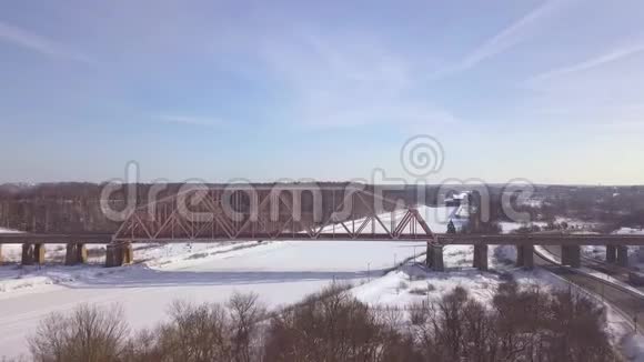 冬季景观鸟瞰图冻河列车交通用悬索铁路桥梁冬季的汽车交通视频的预览图