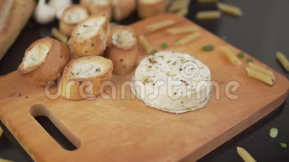 提供加蒜和面包的卡蒙伯特干酪加蒜橄榄油胡椒和面包视频的预览图
