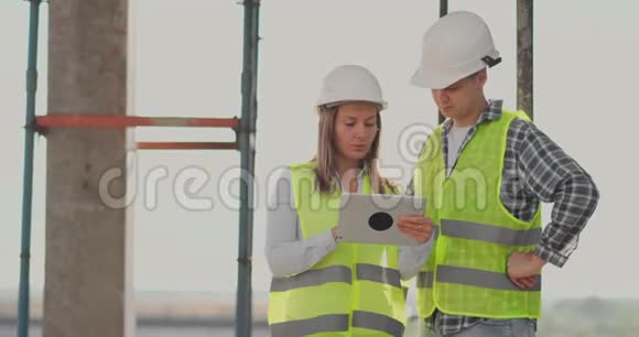 建筑工地小组或建筑师建筑工人或戴头盔的工人在脚手架施工计划或视频的预览图