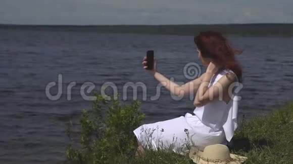 感性的特写肖像美丽的女孩穿着夏天白色的裙子在河上女孩在户外自拍视频的预览图