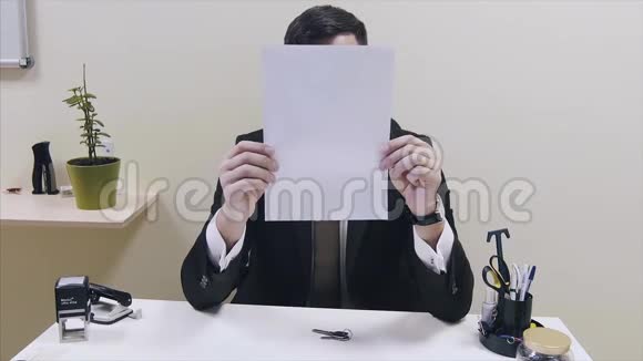 办公室里的人用纸闭上脸办公室工作人员用上级的一张纸遮住她的脸视频的预览图
