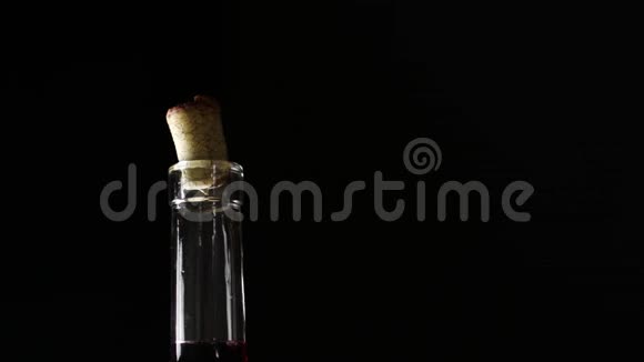 深色背景下的一瓶酒一个人手拿着瓶子倒酒视频的预览图