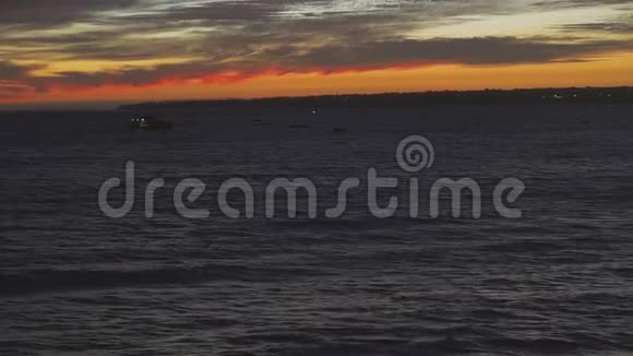 令人惊叹的日落色彩帆船的轮廓漂浮在海洋地平线上视频的预览图