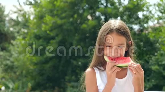 美丽的黑发小女孩长发在外面吃西瓜4K慢动作视频的预览图
