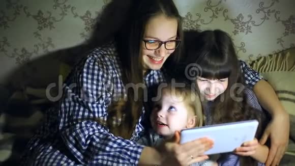 妈妈和孩子们在家拿着平板电脑看动画片和玩视频的预览图