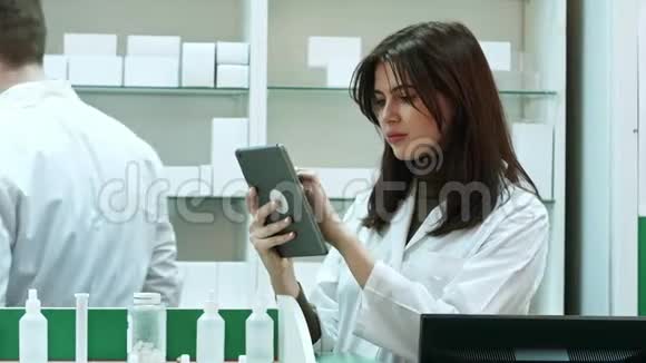 女药师用数码平板电脑寻找药物视频的预览图
